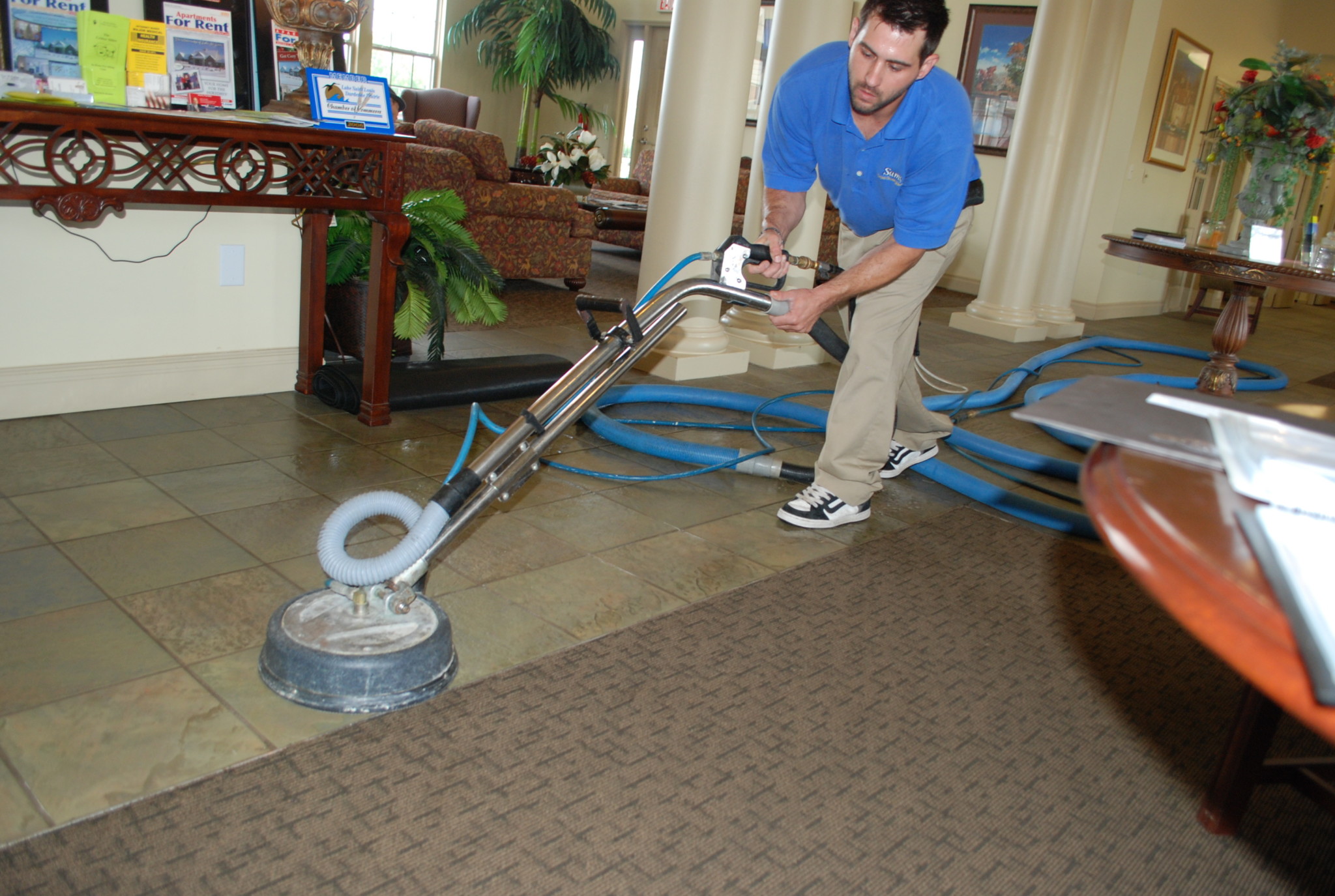 Sams carpet cleaning technician cleaning tile and grout for a St. Louis homeowner