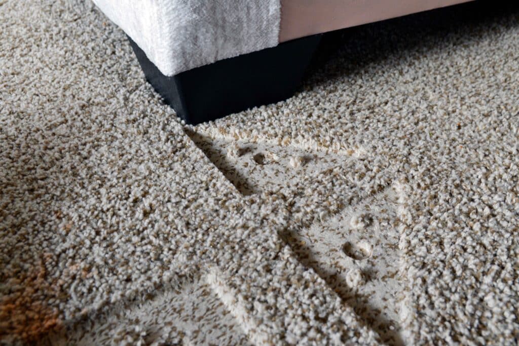 Indentations from furniture in beige carpet in living room